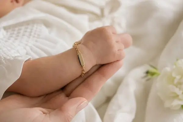 Le bras d'un bébé qui porte une gourmette personnalisée